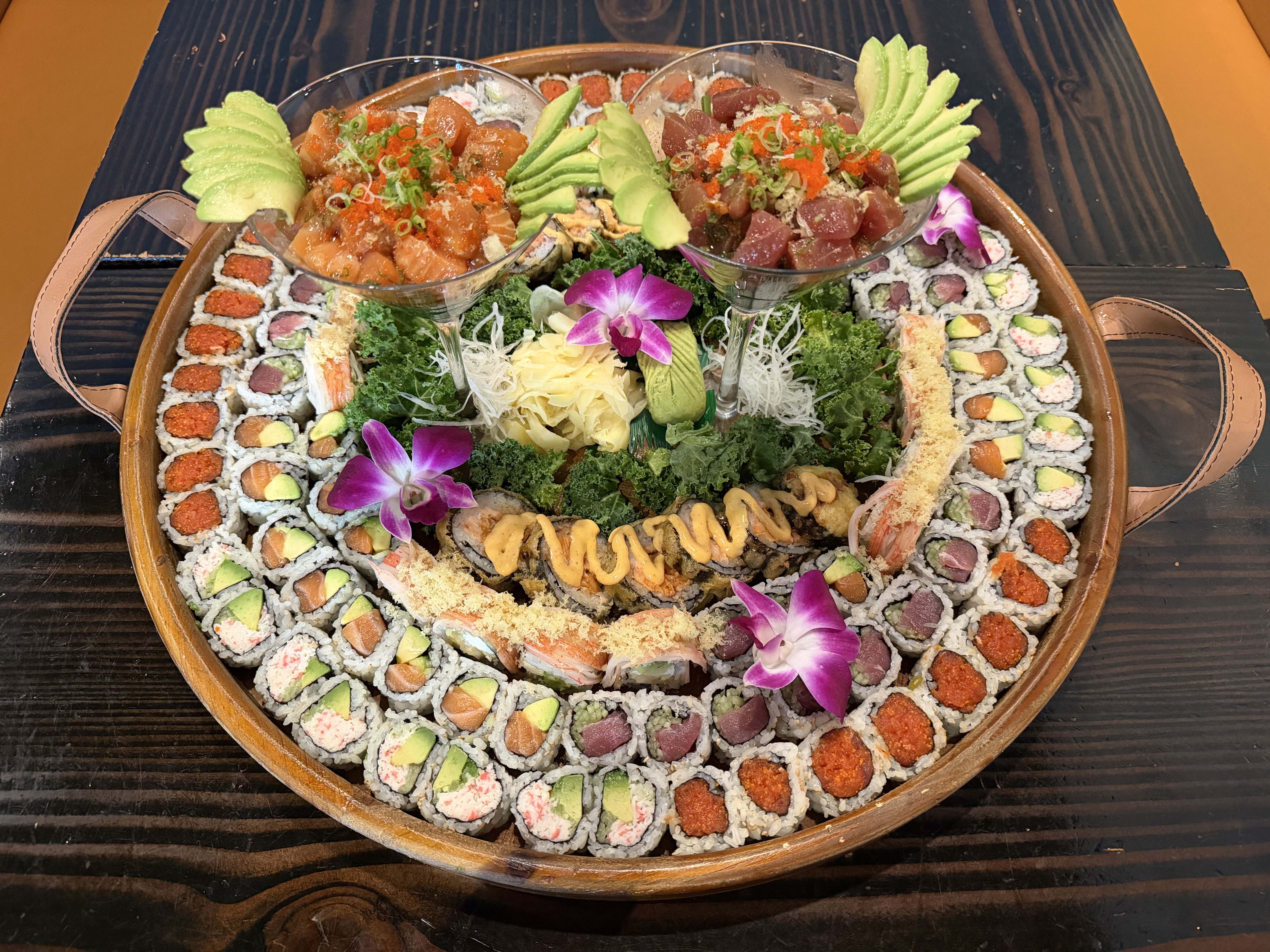 Grand party platter with poke bowls, sashimi, and assorted rolls